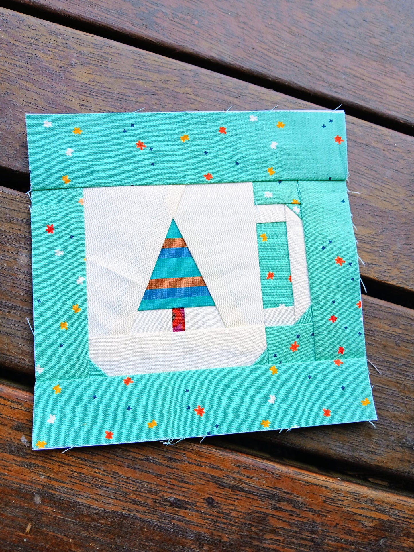 Quilt block with a tree design on a wooden surface