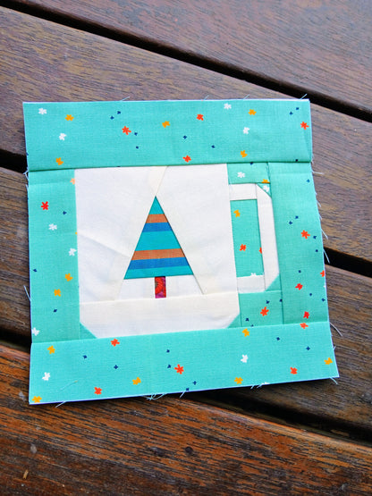Quilt block with a tree design on a wooden surface